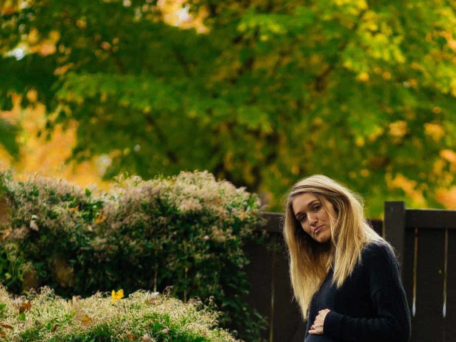 woman standing near brown wooden fence