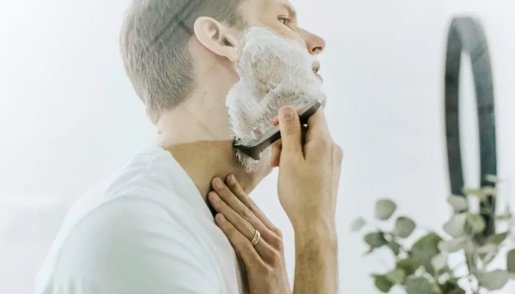 man shaving his beard